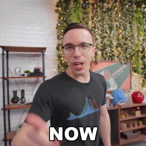 A Man Wearing Glasses And A Black Shirt With The Word Now On It GIF