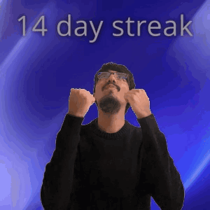 A Man Wearing Glasses And A Black Sweater Stands In Front Of A Blue Background With The Words 14 Day Streak Above Him GIF