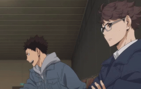 A Man Wearing Glasses And A Blue Jacket Is Standing Next To Another Man GIF