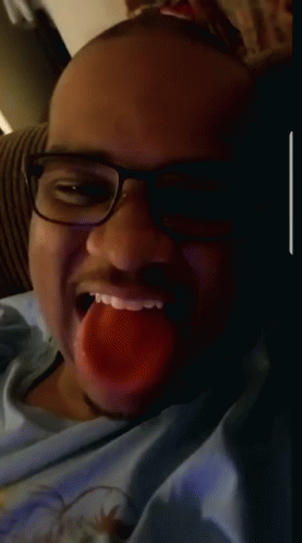 A Man Wearing Glasses And A Blue Shirt Is Making A Face GIF