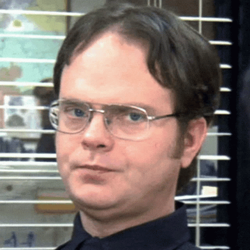 A Man Wearing Glasses And A Blue Shirt Is Making A Funny Face GIF