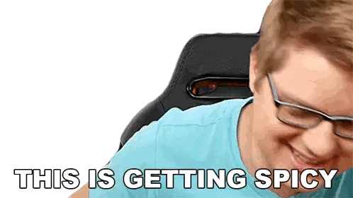 a man wearing glasses and a blue shirt is smiling with the words " this is getting spicy " below him