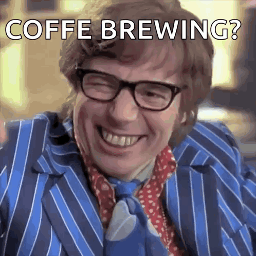 a man wearing glasses and a blue striped suit is smiling with the words coffe brewing below him