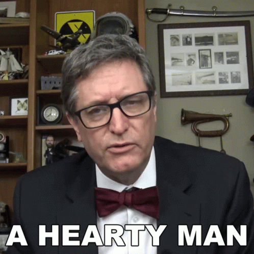 A Man Wearing Glasses And A Bow Tie Has The Words A Hearty Man Below Him GIF