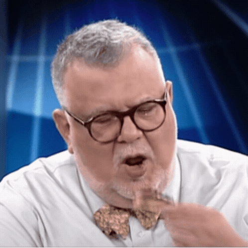 A Man Wearing Glasses And A Bow Tie Is Making A Face GIF