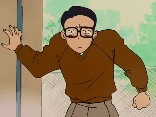 A Man Wearing Glasses And A Brown Sweater Stands In Front Of A Door GIF