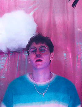 A Man Wearing Glasses And A Chain With The Letter P On It GIF
