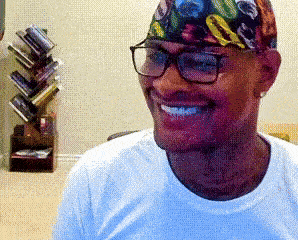 A Man Wearing Glasses And A Colorful Headband Smiles GIF