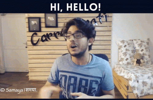 A Man Wearing Glasses And A Dare T-Shirt Is Saying Hi Hello GIF