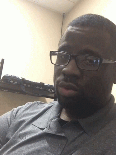 A Man Wearing Glasses And A Gray Shirt GIF