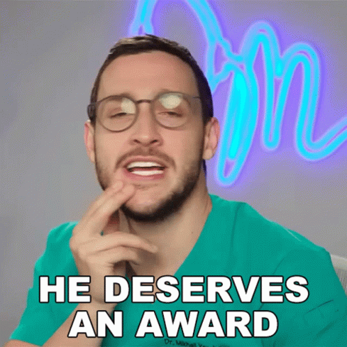 A Man Wearing Glasses And A Green Scrub Shirt Says He Deserves An Award GIF
