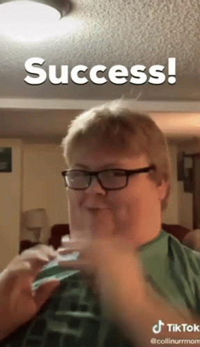 A Man Wearing Glasses And A Green Shirt Is Making A Funny Face And The Caption Says Success GIF