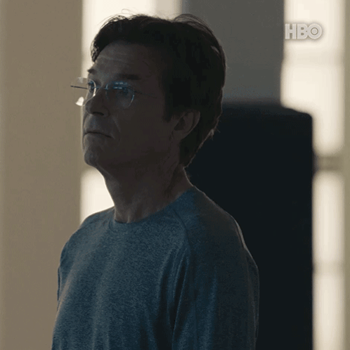A Man Wearing Glasses And A Grey Shirt With Hbo On The Bottom Right GIF