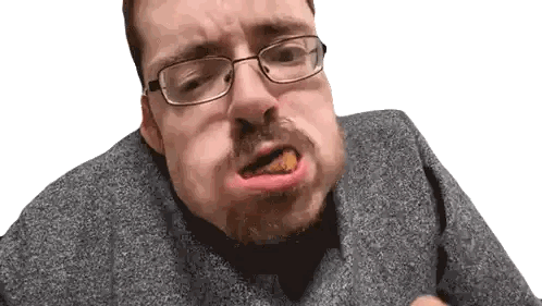 a man wearing glasses and a grey sweater is eating something