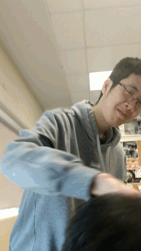 A Man Wearing Glasses And A Grey Sweatshirt Has A Name Tag That Says ' Chris ' GIF
