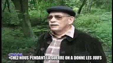 A Man Wearing Glasses And A Hat Is Standing In The Woods And Says Chez Nous GIF