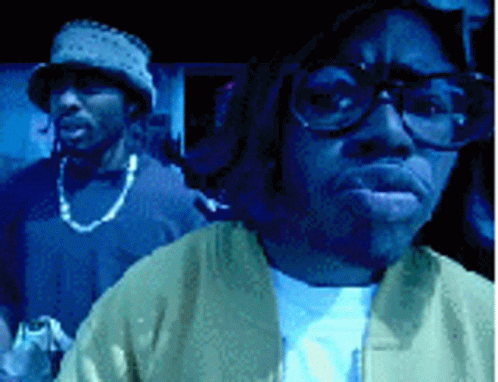 Man With Glasses And Hat Standing Next To Another Man GIF