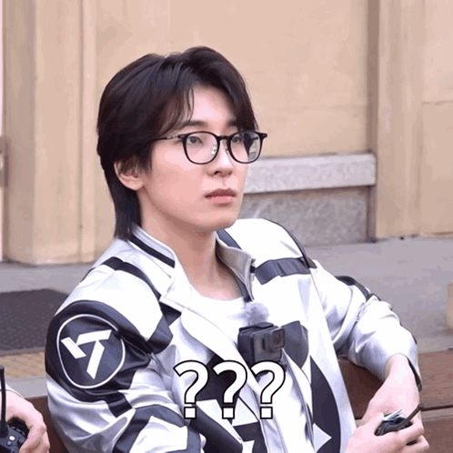 A Man Wearing Glasses And A Jacket With A Question Mark GIF