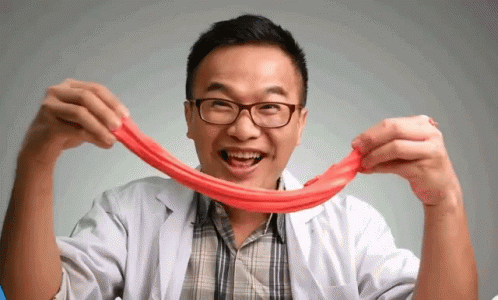 A Man Wearing Glasses And A Lab Coat Is Holding A Red String GIF