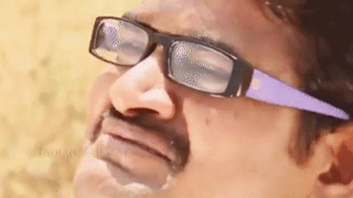 A Man Wearing Glasses And A Mustache Is Making A Face . GIF