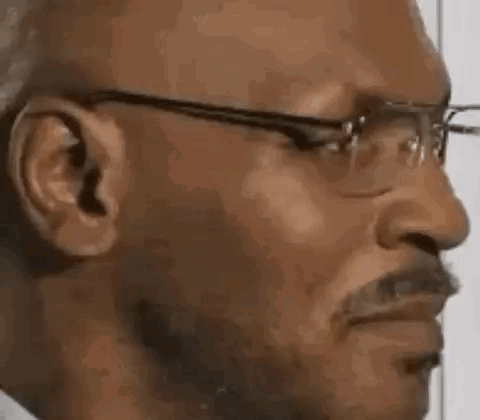A Man Wearing Glasses And A Mustache Is Making A Funny Face . GIF