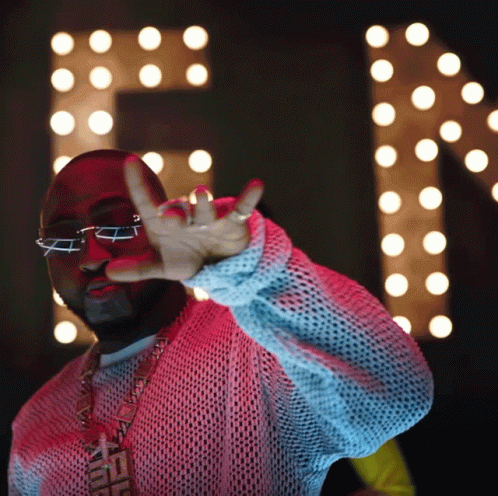 A Man Wearing Glasses And A Necklace That Says Fendi Is Making A Peace Sign GIF