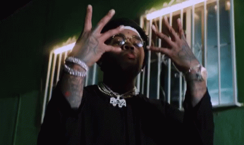 A Man Wearing Glasses And A Necklace With The Letters Bpa On It GIF