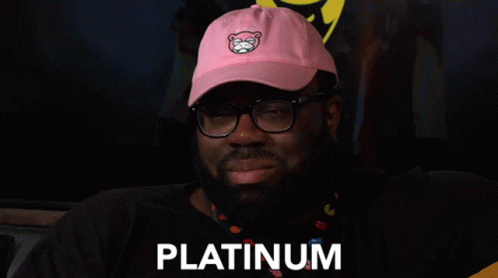 A Man Wearing Glasses And A Pink Hat With The Word Platinum On It GIF