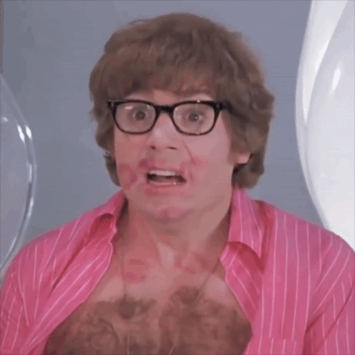 A Man Wearing Glasses And A Pink Shirt Has Red Lipstick On His Chest GIF