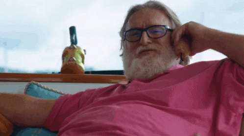 A Man Wearing Glasses And A Pink Shirt Is Talking On A Phone GIF