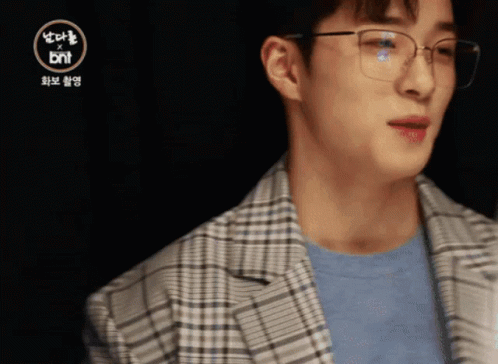 A Man Wearing Glasses And A Plaid Jacket With The Bnt Logo In The Corner GIF