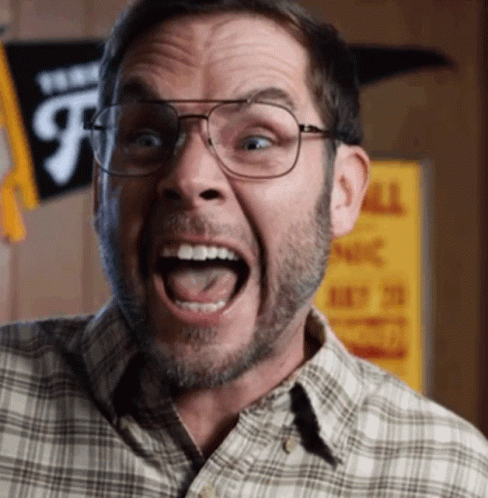 A Man Wearing Glasses And A Plaid Shirt Is Making A Funny Face With His Mouth Open GIF