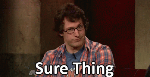 A Man Wearing Glasses And A Plaid Shirt Is Sitting In Front Of A Sign That Says Sure Thing . GIF
