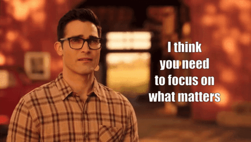 A Man Wearing Glasses And A Plaid Shirt Says " I Think You Need To Focus On What Matters " In Front Of A Building GIF