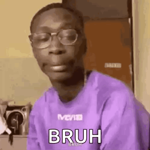 A Man Wearing Glasses And A Purple Shirt Is Making A Face . GIF