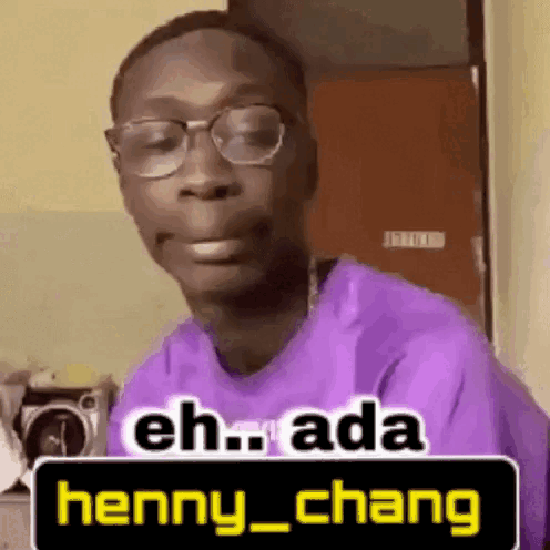 A Man Wearing Glasses And A Purple Shirt Is Making A Funny Face And Saying Eh Ada Henny Chang . GIF
