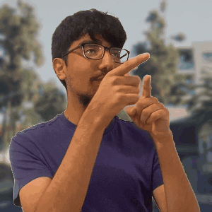 A Man Wearing Glasses And A Purple Shirt Is Pointing His Finger At Something GIF