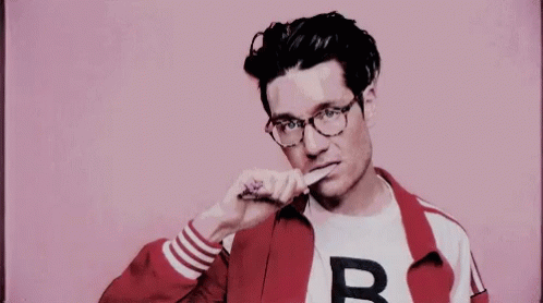 A Man Wearing Glasses And A Red Jacket Is Brushing His Teeth With A Toothbrush . GIF