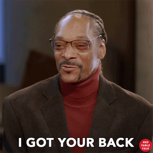A Man Wearing Glasses And A Red Turtleneck Is Smiling And Says I Got Your Back GIF