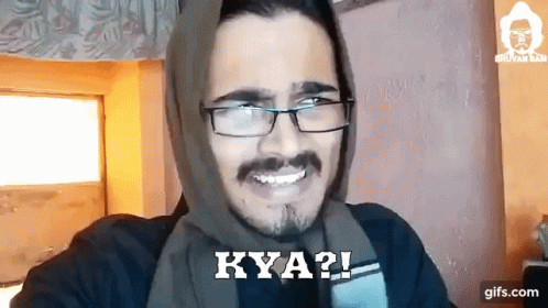 A Man Wearing Glasses And A Scarf On His Head Is Smiling And Says Kya ? GIF