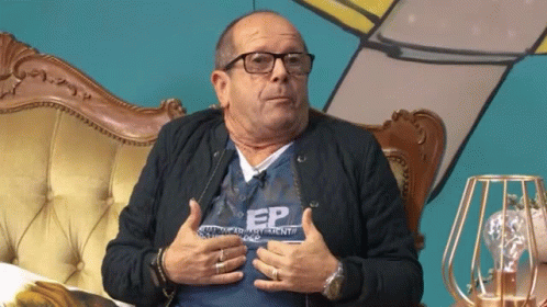 A Man Wearing Glasses And A Shirt That Says Ep Is Sitting On A Couch GIF