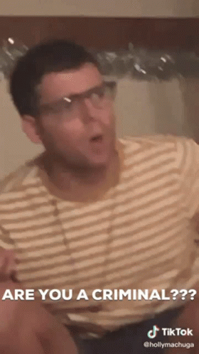 A Man Wearing Glasses And A Striped Shirt Says Are You A Criminal GIF