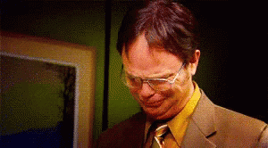 A Man Wearing Glasses And A Suit Is Making A Funny Face . GIF