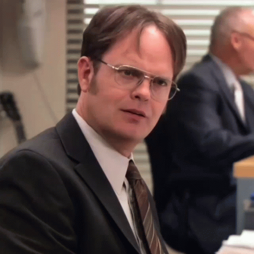 a man wearing glasses and a suit looks serious