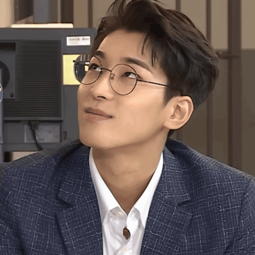 A Man Wearing Glasses And A Suit Looks Up GIF