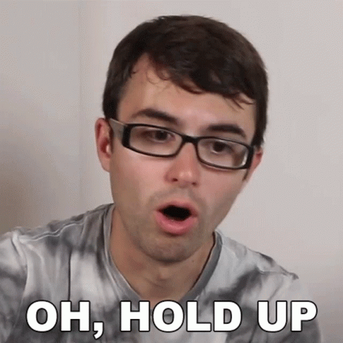 A Man Wearing Glasses And A Tie Dye Shirt Is Saying Oh Hold Up GIF