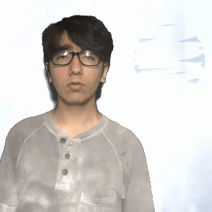 A Man Wearing Glasses And A Tie Dye Shirt Stands In Front Of A White Background GIF