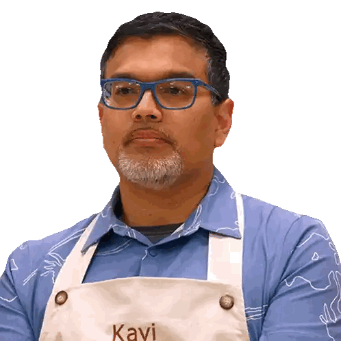 a man wearing glasses and a white apron with the name kavi on it