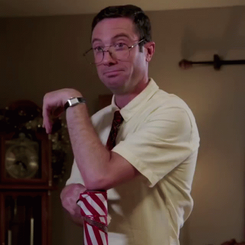 A Man Wearing Glasses And A White Shirt Is Holding A Red And White Striped Shirt GIF