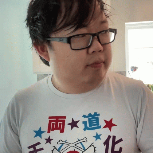 A Man Wearing Glasses And A White Shirt With Chinese Writing GIF